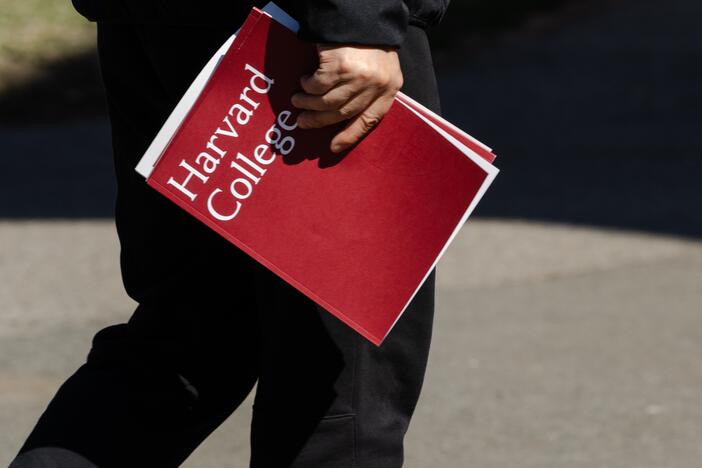 A person holds a Harvard College folder during a tour at Harvard University on April 17 in Cambridge, Mass.