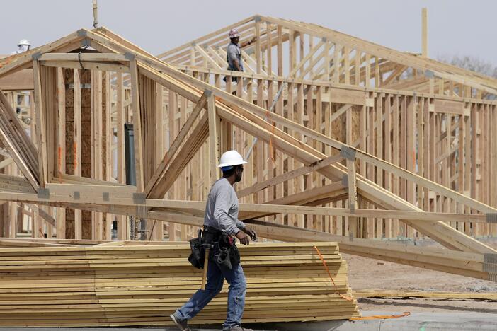 Homebuilding has slowed as Americans face economic uncertainty and high mortgage rates. Here, construction workers install a lumber roof on a new home last month in Laveen, Ariz.