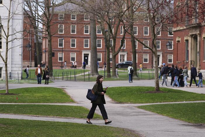 Pedestrians walk through Harvard Yard at Harvard University, Tuesday, April 15, in Cambridge, Mass.