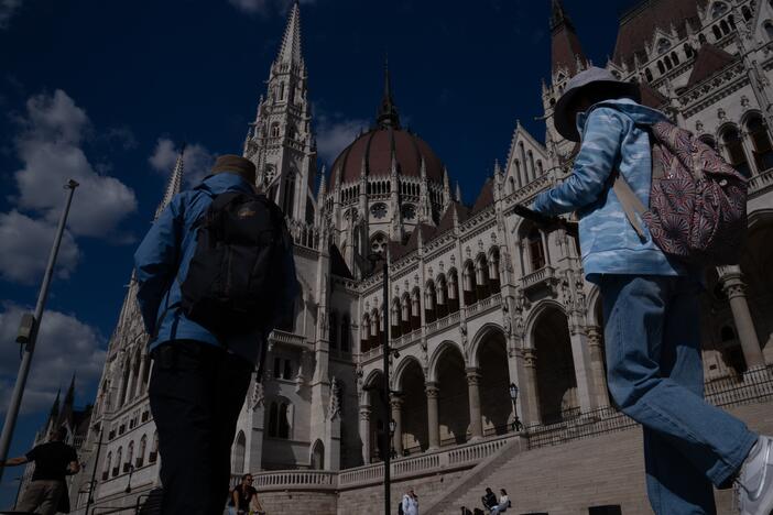 People walk past Hungary's parliament building in Budapest in May.