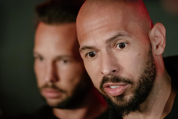 Andrew Tate and his brother Tristan Tate talk to the media outside their residence on March 23, 2025 in Bucharest, Romania.