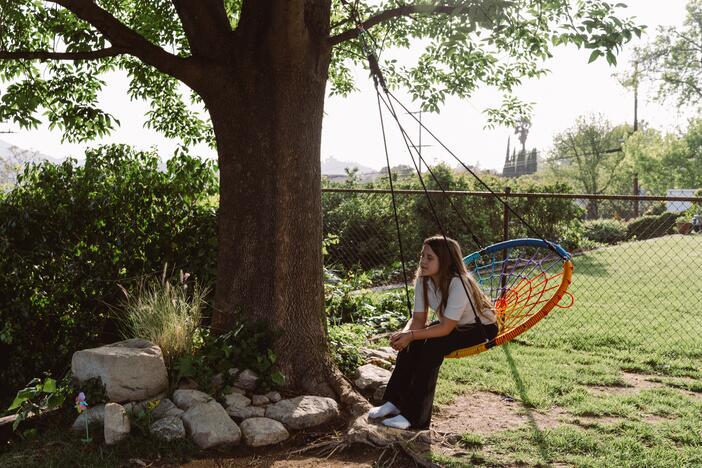 Emory Stumme takes a moment to reflect on a tree swing outside of her new home in La Crescenta-Montrose, Calif.