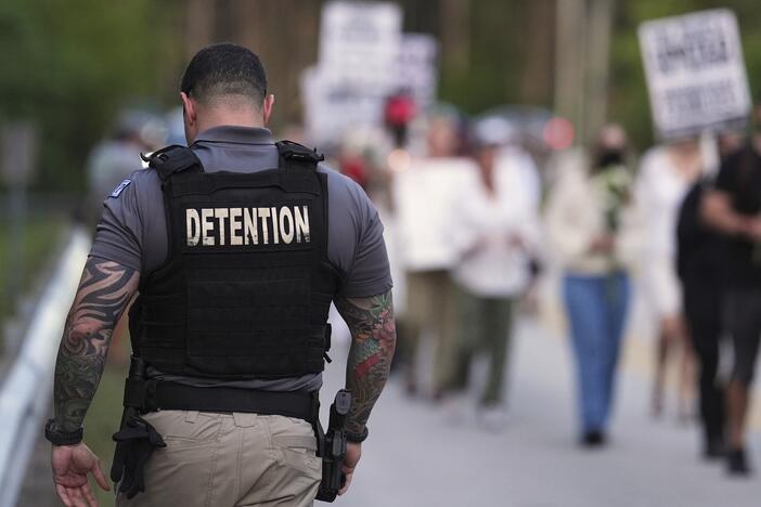 A Krome Detention Center officer patrols as people hold a vigil on May 24 to recognize those who have died in U.S. Immigration and Customs Enforcement custody as well as those affected by mass deportations, outside Krome Detention Center in Miami.