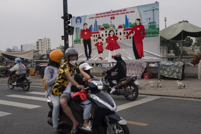 A billboard campaigning for each family to have two children hangs above a street in Ho Chi Minh City, Vietnam, Jan. 14, 2024.