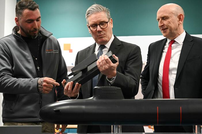 British Prime Minister Keir Starmer (center) and Britain's Defence Secretary John Healey (right) meet with BAE system apprentices as they look at a submarine model during a joint visit on March 20 in Barrow-in-Furness, United Kingdom. Starmer says the U.K. must upgrade its military in response to threats from Russia.
