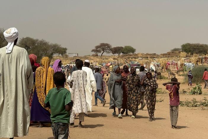 People who fled violence in Darfur walk through a makeshift encampment in the western Darfur region on April 13, 2025.