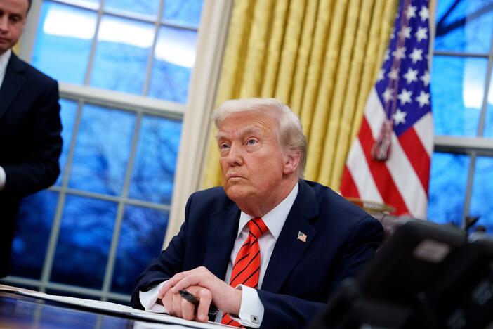 U.S. President Donald Trump, accompanied by White House staff secretary Will Scharf (L), appears at the Resolute Desk as he signs a series of executive orders including 25% tariffs on steel and aluminum, a pardon for former Illinois Gov. Rod Blagojevich, an order relating to the Foreign Corrupt Practices Act, and an order for the federal government to stop using paper straws and begin using plastic straws in the Oval Office at the White House on February 10 in Washington, D.C.