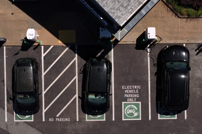 In an aerial view, electric cars sit parked at a charging station in Corte Madera, Calif., on May 15. Federal tax credits that have encouraged the purchase of electric vehicles could be phased out, depending on what happens with negotiations over the Republican tax and spending package currently before the Senate.