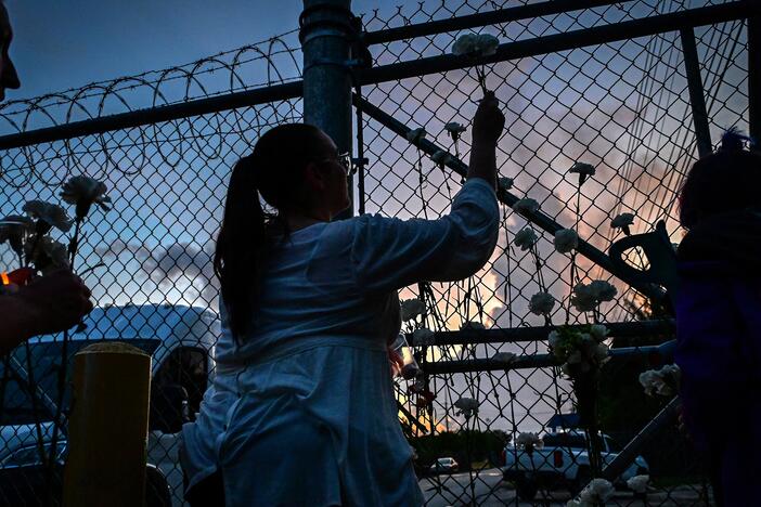 People place white carnation flowers on the fence of the Krome Detention Center during a vigil protesting US Immigration and Customs Enforcement custody and mass deportations in Miami on May 24, 2025.