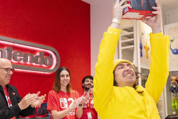 Nintendo of America President Doug Bowser sells a Nintendo Switch 2 system to a Christopher Evangelista, a fan who says he camped out for two months outside Nintendo New York to be first in line for the console.