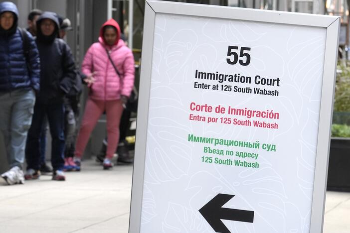 People wait in a cue before being led into a downtown Chicago building where an immigration court presides in November 2024 in Chicago.