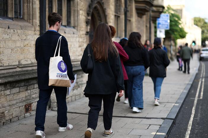 A tour guide walks with a group of people attending an Uncomfortable Oxford Tour, in Oxford, on Oct. 20, 2023.