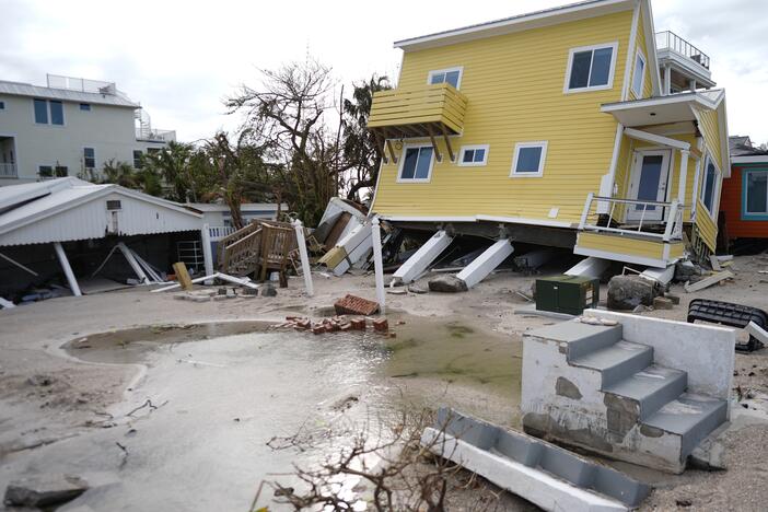 A house, center, lies toppled off its stilts after the passage of Hurricane Milton, alongside an empty lot where a home was swept away by Hurricane Helen, in Bradenton Beach on Anna Maria Island, Fla., on Thursday.