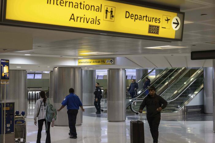 Travelers pass through Newark Liberty International Airport's international terminal after President Trump's new travel ban took effect on Monday.