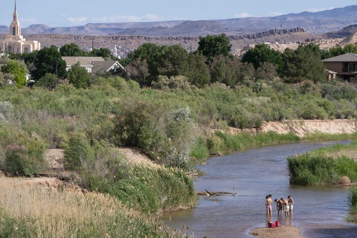 People wade in the shallow waters of the Virgin River in St. George, Utah. The river provides the desert community with water, but climate change and a growing population threaten that supply. Local leaders are looking toward recycled sewage as a solution.