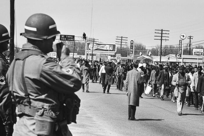 Soldiers watch civil rights protesters walking during the third Selma March in Alabama, on March 25, 1965. President Lyndon Johnson federalized the Alabama National Guard to prevent violence against the marchers.