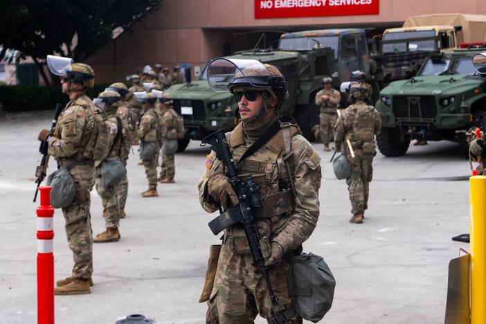 National Guard troops stand outside the Metropolitan Detention Center on Sunday in Los Angeles. Tensions in the city remain high after the Trump administration called in the National Guard against the wishes of city leaders following two days of clashes with police during a series of immigration raids.