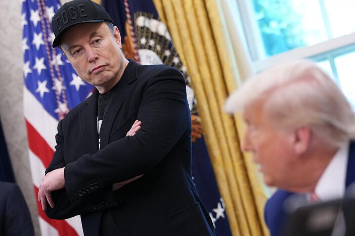 Elon Musk listens as President Trump speaks to reporters in the Oval Office on May 30. A week after the two traded social media disses and threats, Musk said Wednesday some of his posts "went too far."