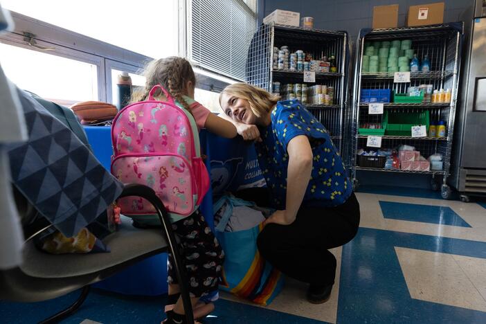 Megan Mainzer, the McKinney-Vento liaison for Middletown Public Schools in Rhode Island, speaks with a young girl at a school food and clothing pantry that's managed, in part, with federal grant money.
