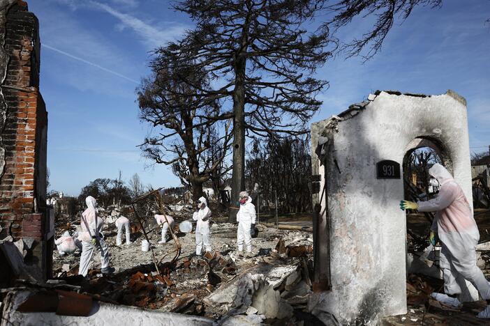 Volunteers help a homeowner search for personal items in the remains of a home that burned in the Palisades Fire in January in Pacific Palisades, California.