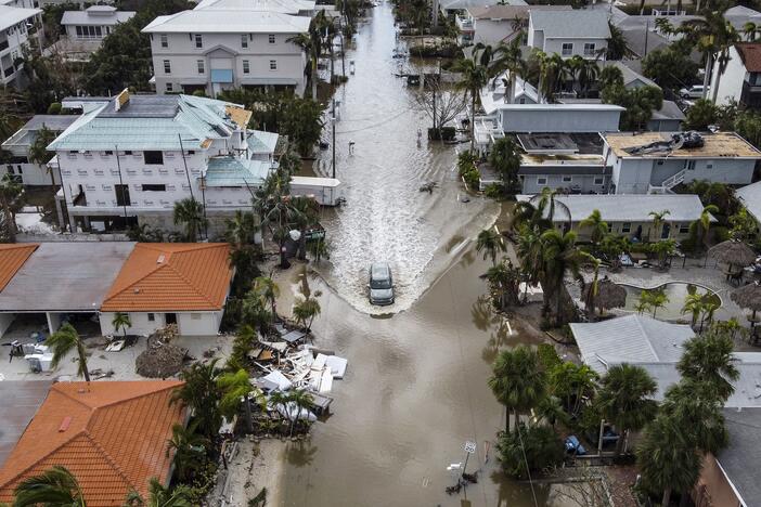 A vehicle drives on a flooded street after Hurricane Milton in Siesta Key, Fla., on Oct. 10, 2024. The monster weather system sent tornadoes spinning across the state and flooded swaths of the Tampa Bay area.