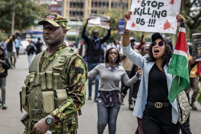 A protester holds a banner and shouts at a Kenyan police officer during a demonstration over the death of Kenyan blogger Albert Ojwang, who died in police custody. June 12 2025