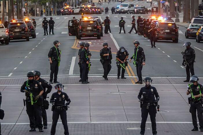 Police fill the streets when the 8:00 PM curfew commences as protests continue in an approximately one-square mile area of downtown Los Angeles in response to a series of immigration raids on June 12, 2025 in Los Angeles, California.