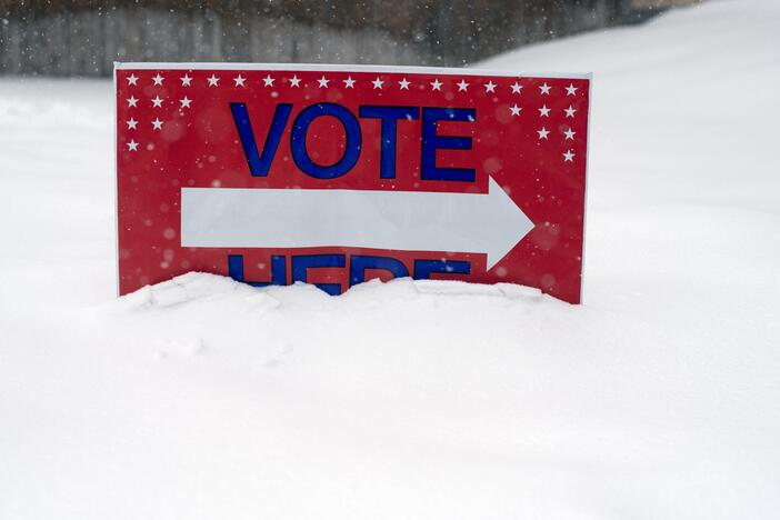 Falling snow piles up and partially covers a sign informing voters where to vote on Election Day, outside the Oak Creek Town Hall in Oak Creek, Colorado, on November 5, 2024.