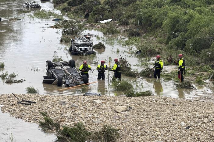 Authorities respond after vehicles were swept away by floodwaters in San Antonio on Thursday.