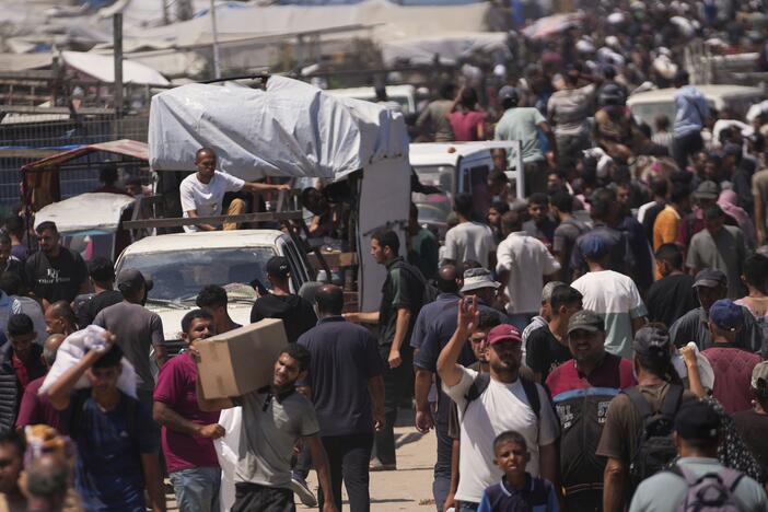 Palestinians carry bags containing food and humanitarian aid packages delivered by the Gaza Humanitarian Foundation, a U.S.-backed organization, in Rafah, southern Gaza Strip, Sunday, June 15, 2025.