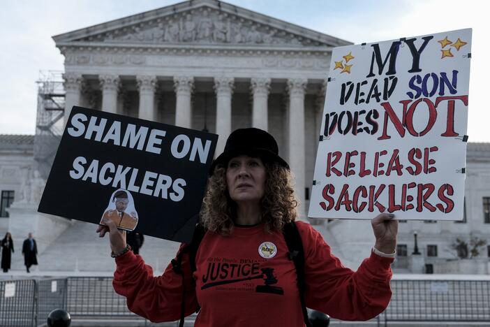 Grace Bisch hold a picture of stepson Eddie Bisch who died as a result of an overdose on outside of the U.S. Supreme Court on December 4, 2023  in Washington, D.C. The Supreme Court overturned a previous version of the Purdue Pharma-Sackler bankruptcy plan, leading to a new deal now under review.