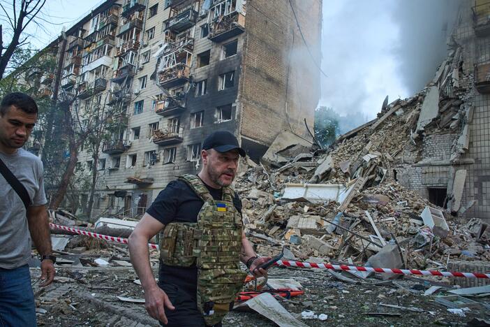 Ukraine Interior Minister Ihor Klymenko, right, examines the site of a missile strike that ruined a residential building during Russia's massive missile and drone air attack in Kyiv, Ukraine, on Tuesday.