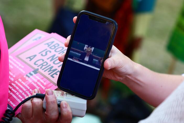 Protesters from 'Abortion Rights' watch Alex Davies-Jones, Parliamentary under-secretary of state at the Ministry of Justice, talk in the House of Commons as they gather near Parliament, where MPs are voting on the decriminalization of abortion on June 17 in London.