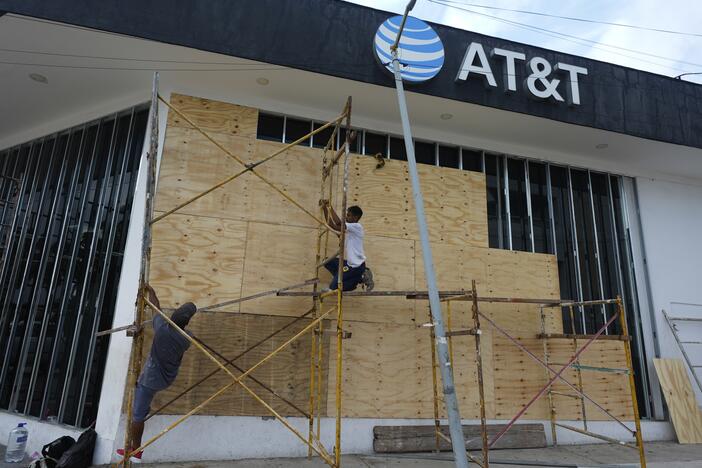 Workers board up a storefront as they prepare for the arrival of Hurricane Erick, in Acapulco, Mexico on Wednesday.