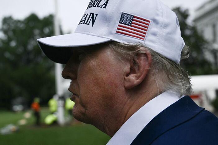 President Trump speaks to the press as workers install a large flag pole on the South Lawn of the White House in Washington, DC on June 18, 2025.