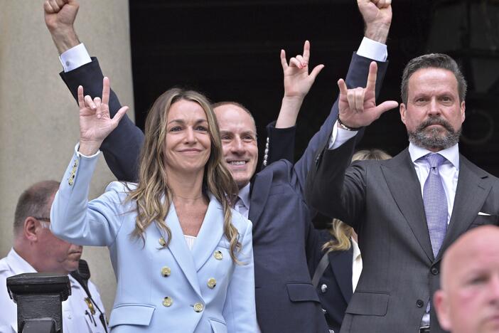 Karen Read and members of her legal team gesture to supporters with the American Sign Language "I love you" sign after she was found not guilty of second-degree murder on Wednesday, in Dedham, Mass.