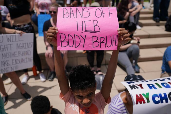 A young boy holds up a sign reading "bans off her body bruh" at a rally outside the State Capitol in support of abortion rights in Atlanta, Georgia on May 14, 2022.