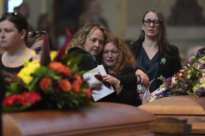 Mourners view the caskets of Melissa and Mark Horman as they enter the Basilica of St. Mary in Minneapolis before their funeral service on Saturday.