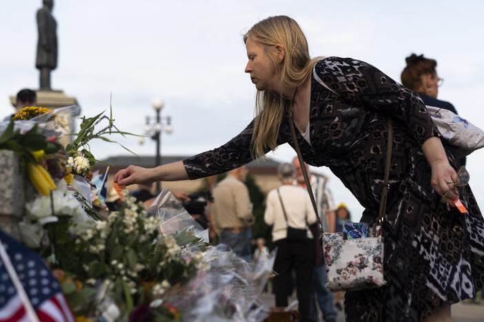Karin Cotter lays a note on a memorial for Melissa and Mark Hortman during a candlelight vigil outside the state Capitol building on June 18 in St. Paul, Minn.