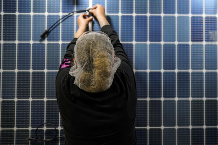 An employee works on a solar panel inside a Qcells factory in Dalton, Ga.