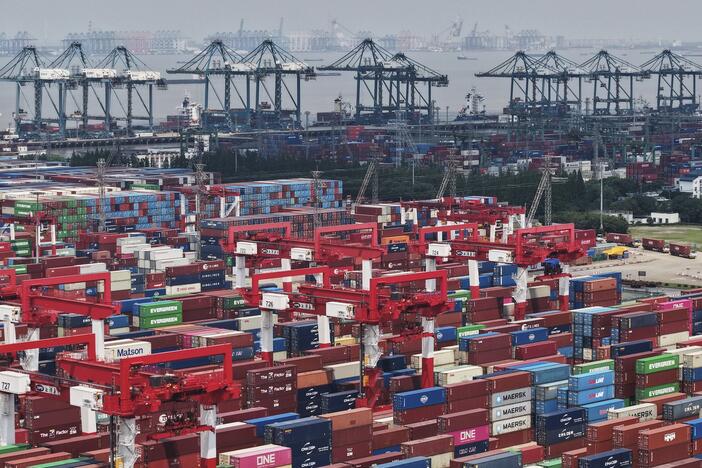 Trucks loaded with containers move through a port in Shanghai, China Monday, June 9, 2025.