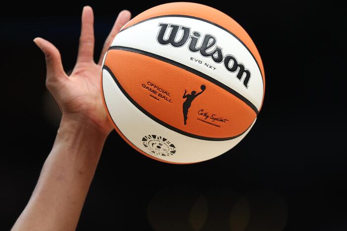 The WNBA logo on the ball is seen as it is tipped during the game between the Seattle Storm and the Las Vegas Aces last year in Seattle, Wash. The WNBA has announced it's expanding to a record 18 teams — adding three new franchises: Cleveland, Detroit and Philadelphia.