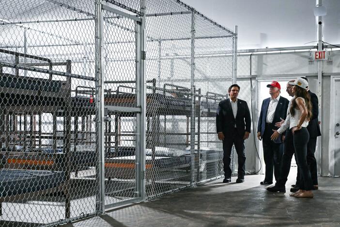 President Donald Trump, along with officials including Florida Gov. Ron DeSantis and Homeland Security Secretary Kristi Noem, tour the new migrant detention facility at the Dade-Collier Training and Transition Airport in Ochopee, Fla., on Tuesday.