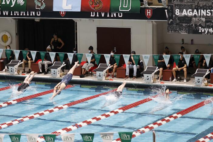 Swimmers including Penn's Lia Thomas, lane 4, dive into the water at the start of a qualifying heat of the 200 yard freestyle at the Ivy League Women's Swimming and Diving Championships at Harvard University, Feb. 18, 2022, in Cambridge, Mass.