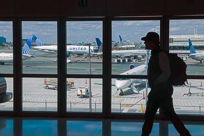 A traveler walks through Newark Liberty International Airport in early June. United Airlines says Newark was the most reliable airport in the New York City area in June — a remarkable turnaround after a wave of cancellations and delays in April and May.