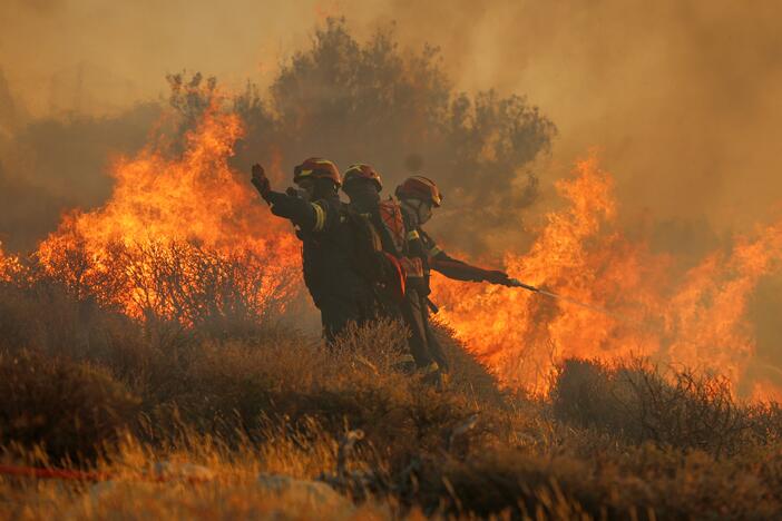 Firefighter uses a hose as the try to extinguish the blaze near the town of Ierapetra on the south coast of Crete island, Greece on Thursday as a fast-moving wildfire prompted authorities to clear villages and coastal areas, officials said.