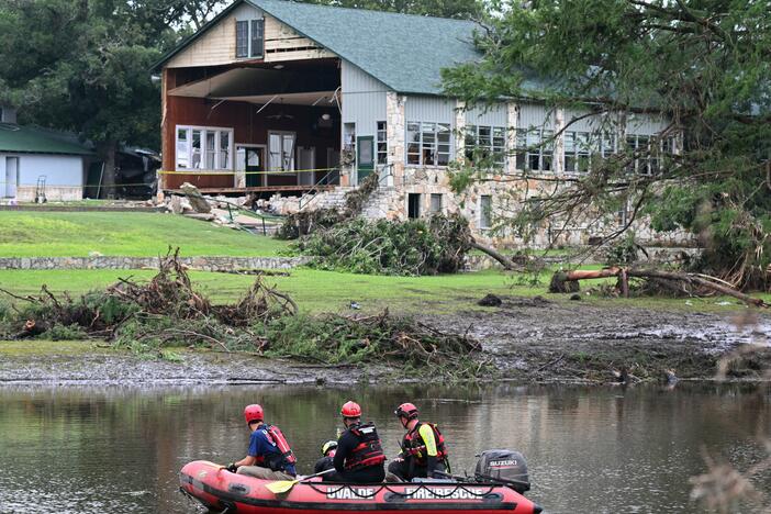 A search and rescue team looks for people along the Guadalupe River near a damaged building at Camp Mystic in Hunt, Texas, on Monday, following severe flash flooding that occurred during the July 4 holiday weekend.