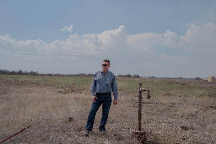 Dan Arthur, the president and chief engineer of ALL Consulting, stands beside a defunct oil well in the Tallgrass Prairie Preserve in Oklahoma on March 20, 2024. The well has not been used for years — there's no pump attached to it. But it hasn't been properly plugged, either.