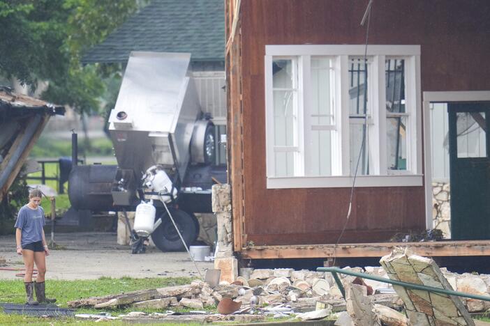 A person looks at damage to the main building at Camp Mystic, along the banks of the Guadalupe River in Texas. A flash flood swept through the area in the early hours of July 4, 2025. Climate change is making heavy rain more common, leading to more flood risk in much of the U.S.