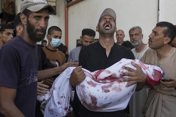 A Palestinian man carries the body of his child, who was killed in an Israeli military airstrike on Gaza, at Shifa Hospital in Gaza City, Saturday, July 12, 2025.